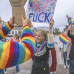 Kvinne holder plakat med "gay as fuck" på