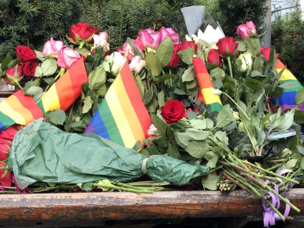 Benk med blomster og regnbueflagg